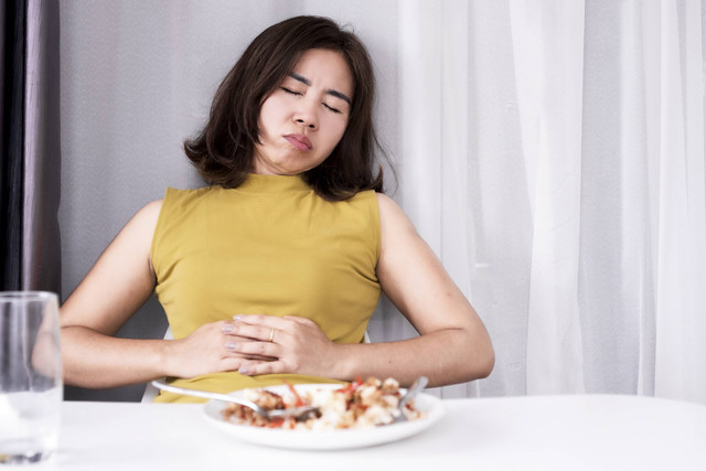 Ilustrasi seseorang mengalami food coma akibat kekenyangan makanan. Foto: Doucefleur/Shutterstock