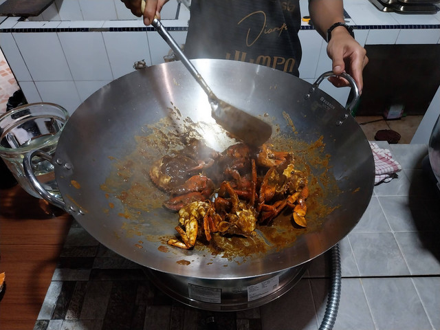 Proses pembumbuan kepiting asap Borneo dengan racikan bumbu rempah nusantara setelah diasap. Foto: Alycia Tracy Nabila/Hi!Pontianak