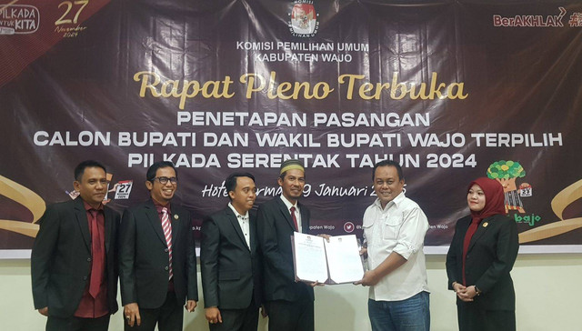 Ketua harian pemenangan pasangan AR-Rahman, Nurman Dai Basri, menerima salinan putusan KPU Wajo pada rapat pleno penetapan Bupati dan Wakil Bupati Wajo terpilih. Foto: Adi Pallawalino