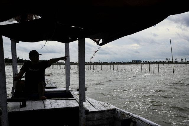 Nelayan menunjukkan pagar laut yang terpasang di kawasan pesisir Kabupaten Tangerang, Banten, Kamis (9/1/2025). Foto: Sulthony Hasanuddin/ANTARA FOTO 