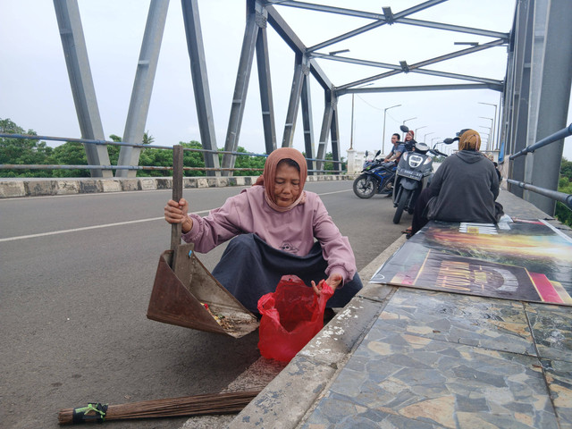 Iis Susilawati penyapu jembatan Sungai Citarum di Karawang. Dok: kumparan