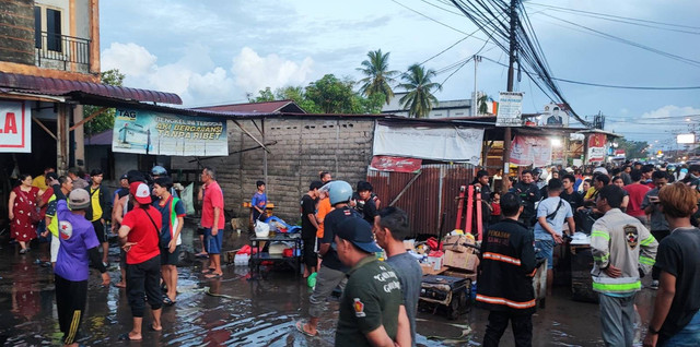 Petugas pemadam saat memadamkan api di kedua ruko yang terbakar. Foto: Dok. Polres Kubu Raya