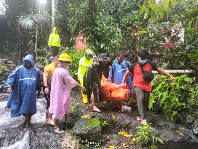 Evakuasi pejalan kaki tewas akibat tersandung batu kemudian terpeleset saat hujan sehingga jalanan licin dan terjatuh ke sungai.  Foto: Dok. Polres Denpasar