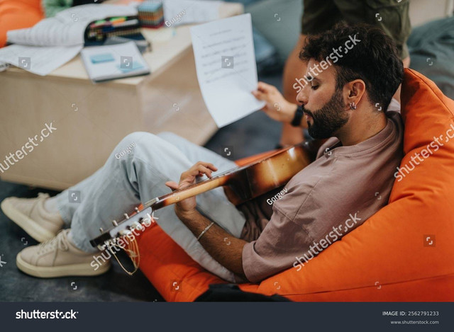 Seorang pria bermain gitar/Shutterstock. 