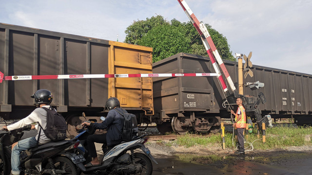 Petugas Jaga Lintasan (PJL) saat melakukan pengerekan palang pintu. | Foto: Eva Nurdiah/Lampung Geh