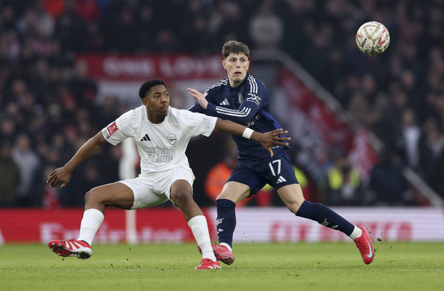 Pemain Arsenal Myles Lewis-Skelly beraksi dengan pemain Manchester United Alejandro Garnacho pada pertandingan Piala FA antara Arsenal vs Manchester United di Stadion Emirates, London, Inggris, Minggu (12/1/2025). Foto: Andrew Couldridge/REUTERS