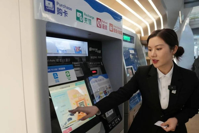 Seorang karyawan mempresentasikan proses pengisian ulang Beijing Pass di Bandara Internasional Ibu Kota Beijing di Beijing, pada 8 Januari 2025. Foto: ANTARA/Xinhua/Ju Huanzong