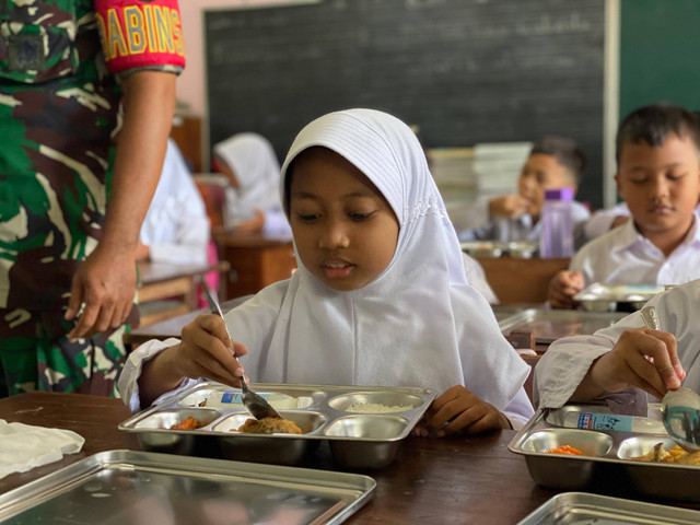 Siswa SD di Sleman menikmati makan bergizi gratis pada hari pertama, Senin (13/1). Foto: Resti Damayanti/Pandangan Jogja