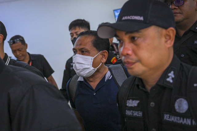 Petugas menggiring mantan Ketua Pengadilan Negeri (PN) Surabaya Rudi Suparmono (tengah) di Bandara Halim Perdanakusuma, Jakarta, Selasa (14/1/2025).  Foto: Muhammad Ramdan/ANTARA FOTO