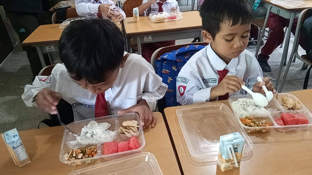 Siswa SD di Surabaya sedang menikmati menu makanan MBG. Foto: Masruroh/Basra