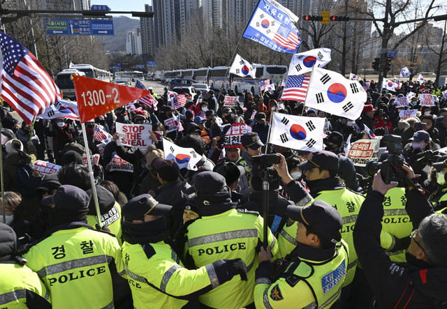 Sejumlah pengunjuk rasa yang tergabung dalam pendukung Presiden Korea Selatan Yoon Soek-yoel melakukan aksi di depan Gedung Pemerintahan, Seoul, Korea Selatan, Rabu (15/1/2025). Foto: Jung Yeon-je/AFP