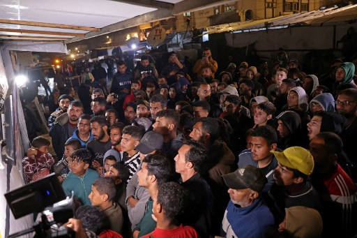 Pengungsi Gaza di Khan Yunis nonton bareng konferensi pers oleh Perdana Menteri Qatar Sheikh Mohammed terkait pengumuman gencatan senjata di Gaza pada Rabu (15/1). Foto: Bashar Taleb/AFP