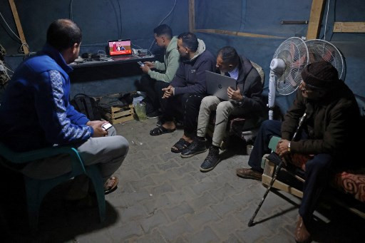 Pengungsi Gaza di Khan Yunis nonton bareng konferensi pers oleh Perdana Menteri Qatar Sheikh Mohammed terkait pengumuman gencatan senjata di Gaza pada Rabu (15/1). Foto: Bashar Taleb/AFP