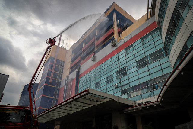 Petugas pemadam kebakaran menggunakan kendaraan High Pressure Pump Unit untuk melakukan pendinginan Glodok Plaza akibat kebakaran, Kamis (16/1/2025). Foto: Iqbal Firdaus/kumparan