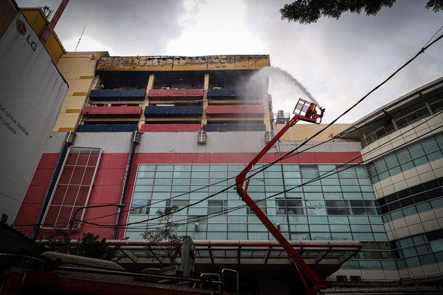 Petugas pemadam kebakaran menggunakan kendaraan High Pressure Pump Unit untuk melakukan pendinginan Glodok Plaza akibat kebakaran, Kamis (16/1/2025). Foto: Iqbal Firdaus/kumparan