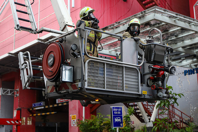 Petugas pemadam kebakaran menggunakan kendaraan High Pressure Pump Unit untuk melakukan pendinginan Glodok Plaza akibat kebakaran, Kamis (16/1/2025). Foto: Iqbal Firdaus/kumparan