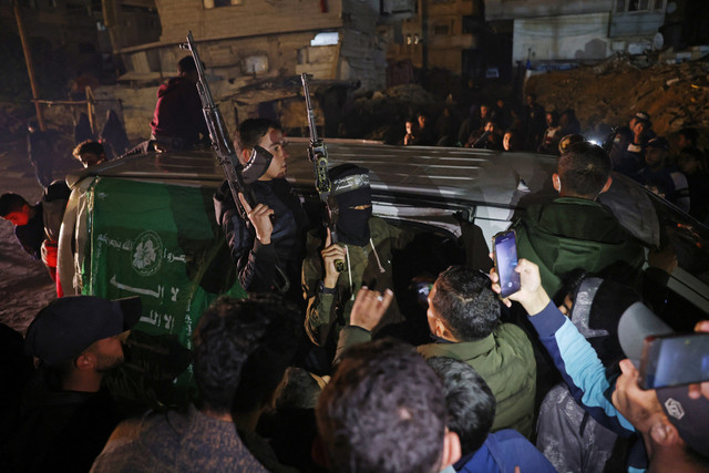 Anggota sayap bersenjata Hamas, Brigade Ezzedine al-Qassam, tiba dengan kendaraan di sebuah jalan di Khan Yunis di Jalur Gaza selatan pada 15 Januari 2025. Foto: Bashar Taleb / AFP