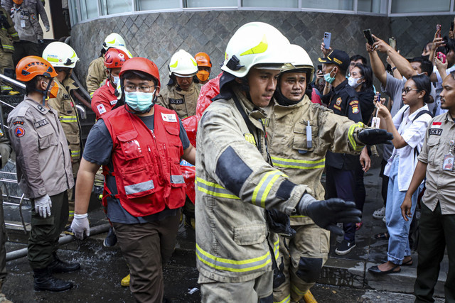 Petugas membawa kantung jenazah korban kebakaran di Glodok Plaza, Kamis (16/1/2025). Foto: Iqbal Firdaus/kumparan