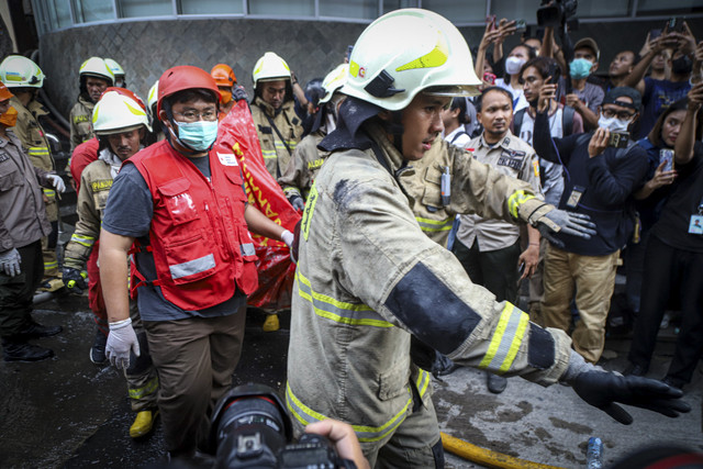 Petugas membawa kantung jenazah korban kebakaran di Glodok Plaza, Kamis (16/1/2025). Foto: Iqbal Firdaus/kumparan