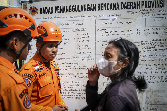 Dua petugas tim SAR berbincang dengan keluarga korban kebakaran di Glodok Plaza, Jakarta, Jumat (17/1/2025). Foto: Iqbal Firdaus/kumparan