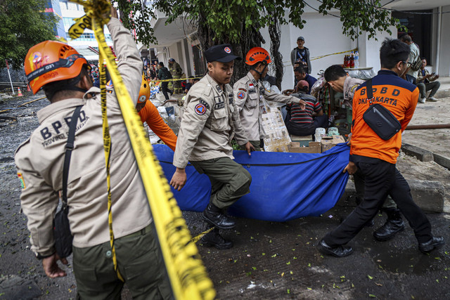 Sejumlah petugas membawa kantung jenazah korban kebakaran di Glodok Plaza, Jakarta, Jumat (17/1/2025). Foto: Iqbal Firdaus/kumparan