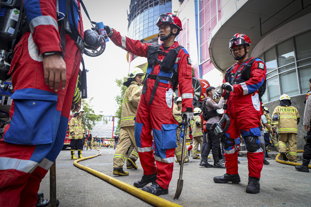 Petugas Damkar berkumpul saat bersiap melakukan pencarian korban kebakaran di Glodok Plaza, Jakarta, Jumat (17/1/2025). Foto: Iqbal Firdaus/kumparan