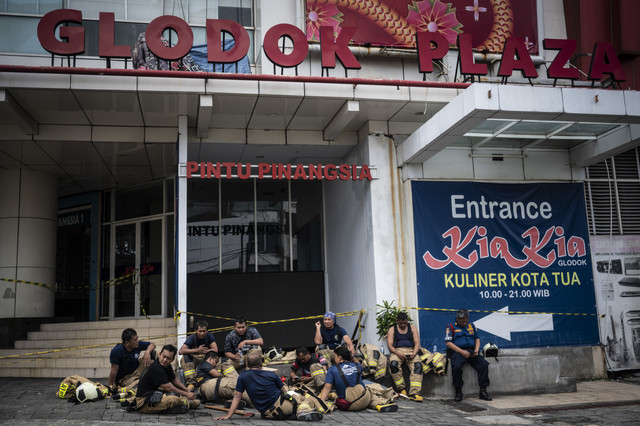 Sejumlah petugas Damkar beristirahat di halaman Gedung Glodok Plaza, Tamansari, Jakarta, Jumat (17/1/2025). Foto: Aprillio Akbar/ANTARA FOTO