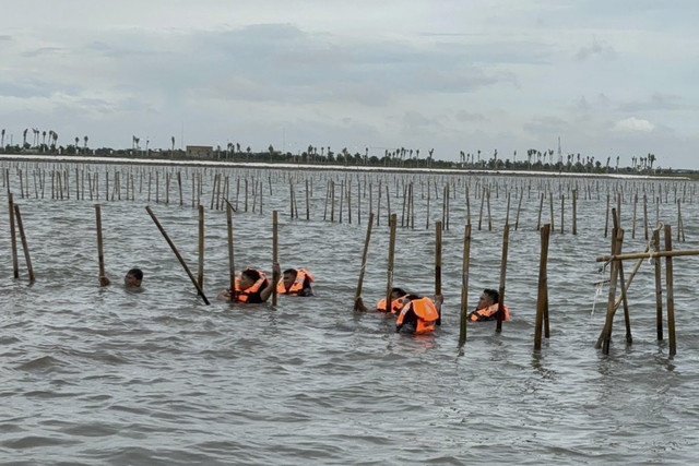 Sejumlah warga dan TNI AL berusaha membongkar pagar laut di perairan Tangerang, Banten, Sabtu (18/1/2025). Foto: Abid Raihan/kumparan