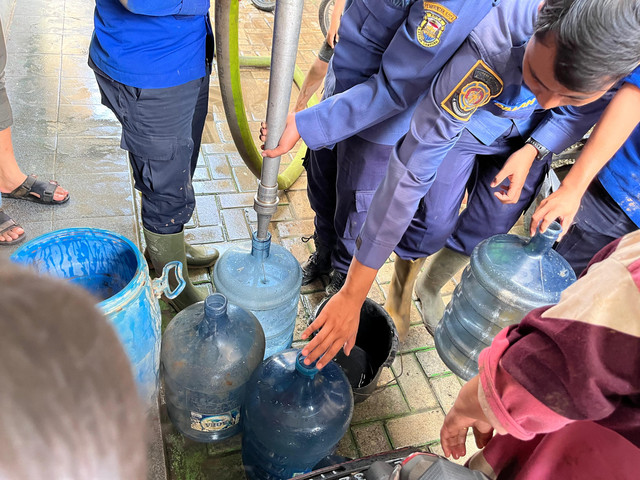 Damkarmat Kota Bandar Lampung menyalurkan air bersih di lokasi warga yang terdampak banjir Jalan RE Marthamartadinata, tepatnya Kampung Pasar Ambon, Pesawahan, Teluk Betung Selatan. | Foto: Sinta Yuliana/Lampung Geh