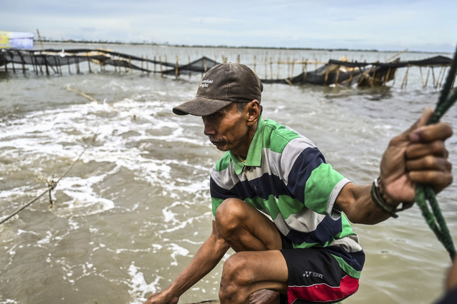 Nelayan membongkar pagar laut yang terpasang di kawasan pesisir Tanjung Pasir, Kabupaten Tangerang, Banten, Sabtu (18/1/2025). Foto: Rivan Awal Lingga/ANTARA FOTO