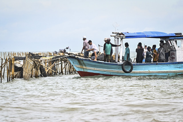 Sejumlah nelayan membongkar pagar laut yang terpasang di kawasan pesisir Tanjung Pasir, Kabupaten Tangerang, Banten, Sabtu (18/1/2025). Foto: Rivan Awal Lingga/ANTARA FOTO