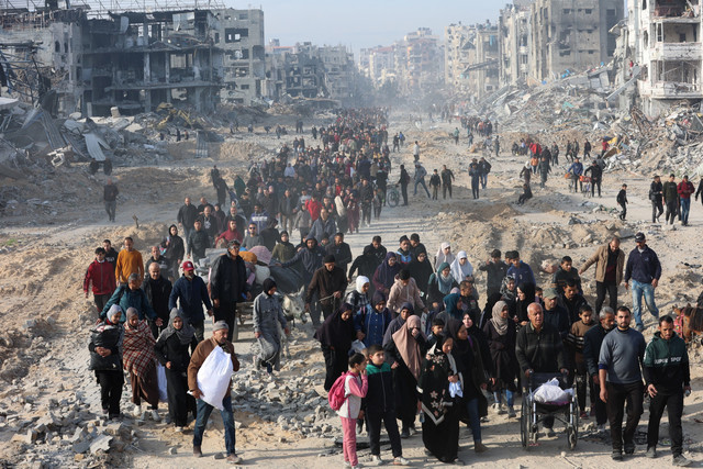 Warga Palestina yang mengungsi berjalan meninggalkan tempat berlindung menuju utara Jalur Gaza menyusul dimulainya gencatan senjata di wilayah Saftawi, Jabalia, Gaza, Minggu (19/1/2025). Foto: Omar AL-QATTAA / AFP