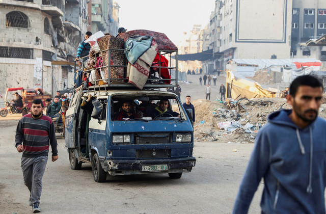 Warga Palestina yang mengungsi membawa barang-barangnya dengan mobil melewati puing-puing mencoba kembali ke rumah menyusul dimulainya gencatan senjata di Jalur Gaza, Minggu (19/1/2025). Foto: Khalil Ramzi/REUTERS