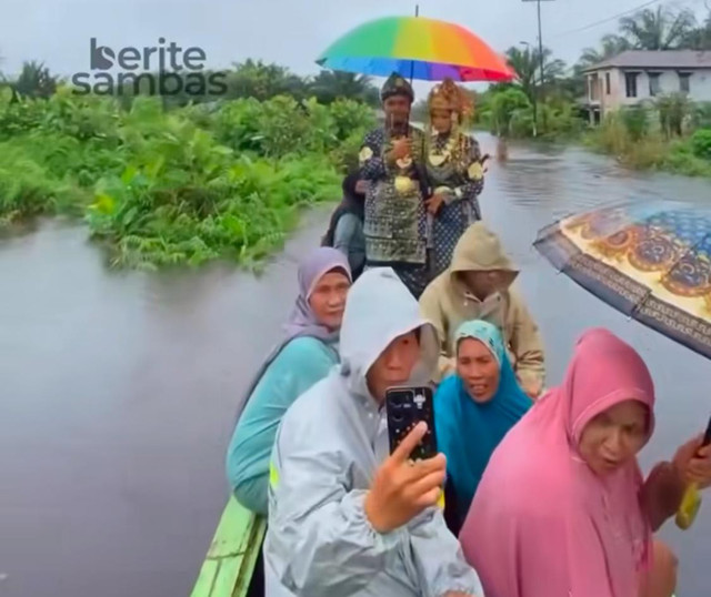 Pasangan pengantin di Sambas diarak menggunakan sampan saat banjir. Foto: Dok. Instagram @beritesambas