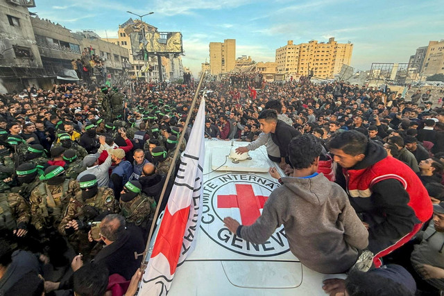 Militan Hamas Palestina berkumpul selama serah terima sandera yang diculik selama serangan 7 Oktober 2023 di Israel oleh Hamas kepada anggota Komite Palang Merah Internasional (ICRC) di Kota Gaza, Minggu (19/1/2025). Foto: Dawoud Abu Alkas/REUTERS