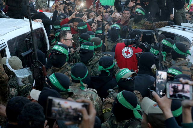 Militan Hamas Palestina berkumpul selama serah terima sandera yang diculik selama serangan 7 Oktober 2023 di Israel oleh Hamas kepada anggota Komite Palang Merah Internasional (ICRC) di Kota Gaza, Minggu (19/1/2025). Foto: Dawoud Abu Alkas/REUTERS