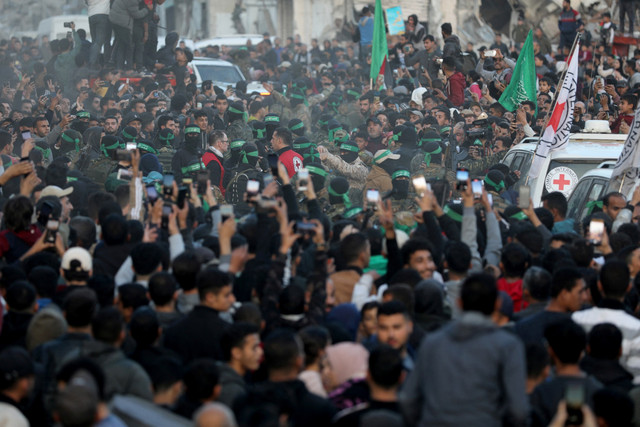 Militan Hamas Palestina berkumpul selama serah terima sandera yang diculik selama serangan 7 Oktober 2023 di Israel oleh Hamas kepada anggota Komite Palang Merah Internasional (ICRC) di Kota Gaza, Minggu (19/1/2025). Foto: Dawoud Abu Alkas/REUTERS