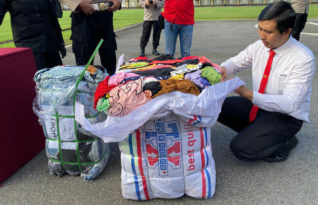 Personel Polda Kalbar saat membuka barang bukti bal pres thrifting. Foto: Yulia Ramadhiyanti/Hi!Pontianak