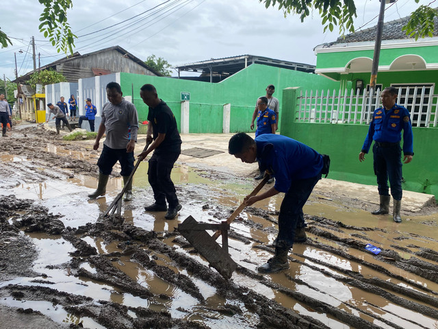 Petugas Damkarmat Bandar Lampung saat membersihkan lumpur sisa banjir di Jalan Ikan Kembung, Pesawahan, Teluk Betung Selatan, Bandar Lampung. | Foto: Sinta Yuliana/Lampung Geh