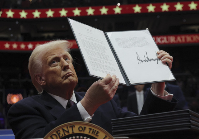 Presiden AS Donald Trump menyampaikan perintah eksekutif saat parade perdana di dalam Capital One Arena pada hari pelantikan masa jabatan presiden keduanya, di Washington, AS, Senin (20/1/2025). Foto: Carlos Barria/REUTERS