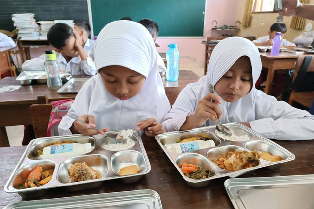 Ilustrasi murid menikmati paket makan program Makan Bergizi Gratis (MBG) di SD Sinduadi Timur, Kapanewon Mlati, Kabupaten Sleman, Senin (13/1/2025). Foto: Arfiansyah Panji Purnandaru/kumparan