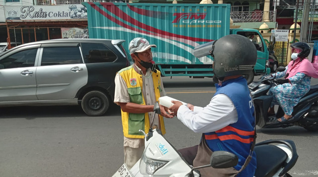 Tim DT Peduli Lubuklinggau sedang membagikan paket makanan Jumat Berkah kepada Pejuang Keluarga (Sumber : DT Peduli)