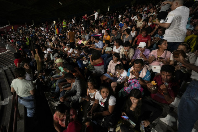 Orang-orang yang mengungsi akibat kekerasan di kota-kota di wilayah Catatumbo, tempat pemberontak Tentara Pembebasan Nasional, atau ELN di salah satu Stadion Colombia, Minggu (19/1/2025). Foto: Fernando Vergara/AP Photo