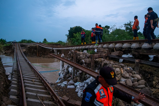 Sejumlah petugas menangani jalur rel kereta api km 32+5/7 antara Stasiun Gubug - Karangjati yang tanggul penyangganya amblas tergerus banjir luapan air Sungai Tuntang di Gubug, Kabupaten Grobogan Jawa Tengah, Selasa (21/1/2025). Foto: Aji Styawan/ANTARA FOTO 