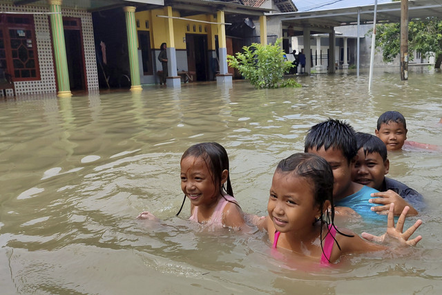 Sejumlah anak bermain air saat banjir merendam Desa Trawasan, Kecamatan Sumobito, Kabupaten Jombang, Jawa Timur, Rabu (22/1/2025). Foto: Syaiful Arif/ANTARA FOTO