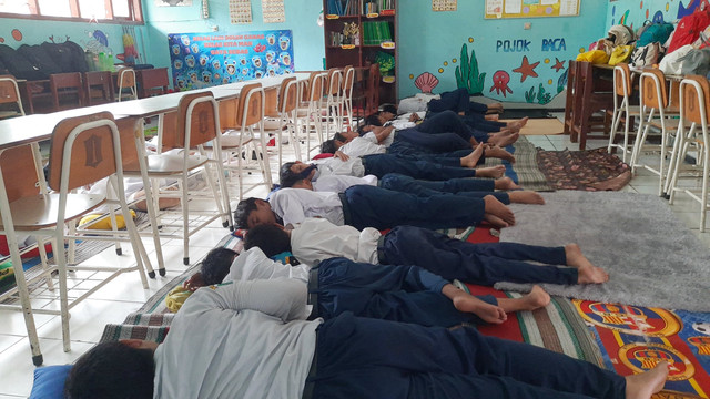 Sejumlah siswa saat tidur siang di kelasnya masing-masing di SMP Negeri 39 Surabaya, Rabu (22/1/2025). Foto: Farusma Okta Verdian/kumparan