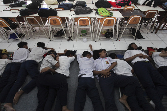 Pelajar tidur siang di sela proses belajar di SMP Negeri 39 Surabaya, Jawa Timur, Rabu (22/1/2025). Foto: Didik Suhartono/ANTARA FOTO