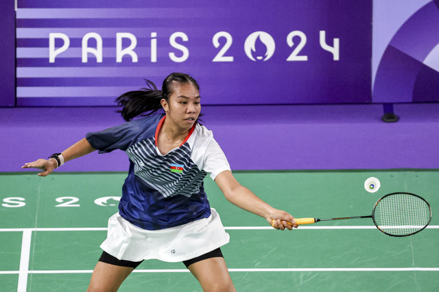 Atlet Azerbaijan Keisha Fatimah Azzahra melakukan pukulan dalam pertandingan penyisihan grup bulu tangkis tunggal putri di Olimpiade Paris 2024 di Porte de la Chapelle Arena di Paris (27/7/2024). Foto: David Gray/AFP