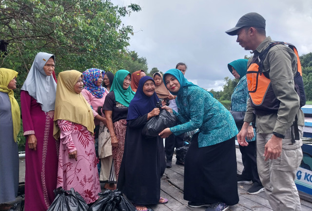 Penjabat Ketua TP PKK Provinsi Kalimantan Barat, Windy Prihastari Harisson, memberikan bantuan sembako beserta perlengkapan alat salat, yakni mukena dan sarung kepada warga pedalaman Kalbar. Foto: Alycia Tracy Nabila/Hi!Pontianak