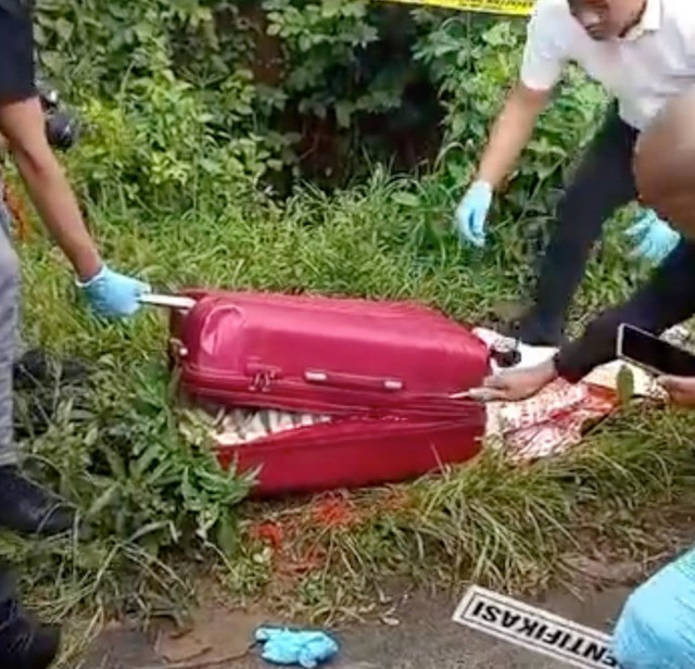 Polisi memeriksa isi koper merah yang berisi mayat wanita di Ngawi, Jawa Timur, Kamis (23/1). Foto: Dok. Istimewa